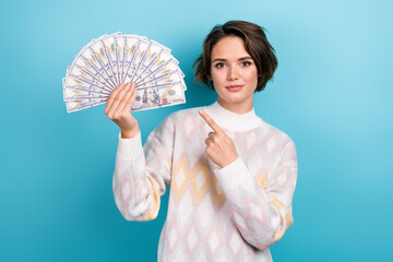 Photo portrait of pretty young girl finger point money fan dollars usd lottery wear trendy white outfit isolated on blue color background