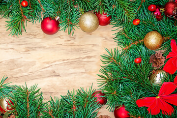 Fototapeta na wymiar Christmas light background with Christmas tree branches and Christmas ornaments on a wooden table. Beautiful festive background for Christmas greeting card
