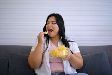 Plus size woman is eating donut.