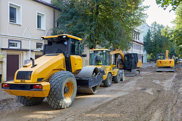 Road construction equipment: excavators, asphalt rollers, bulldozers on a city street with the road...