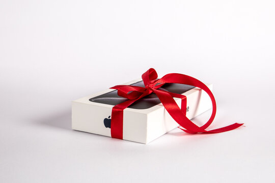 Box of the Iphone 15 Pro on on a white background. Gift with a red ribbon
