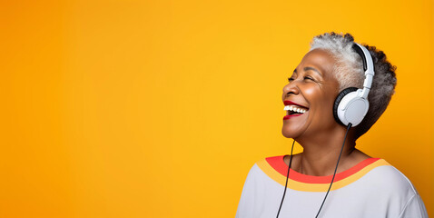 Studio portrait of mature black woman listening on headphones and laughing, yellow background	
 - obrazy, fototapety, plakaty