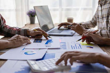 Businessman or accounting team analyzing graph data chart and laptop dashboard to prepare statistical reports and discuss financial data to analyze market data. Close-up image