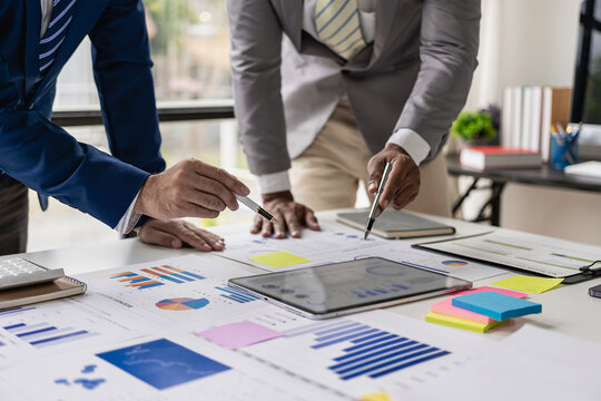 Businessman or accounting team analyzing graph data chart and laptop dashboard to prepare statistical reports and discuss financial data to analyze market data. Close-up image
