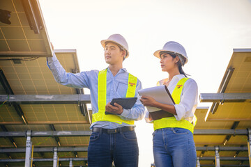 Electrical, instrument technician survey, checking, maintenance electric system at solar panel field in sunny day.