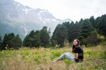 Happy girl in the summer in the mountains in the rain