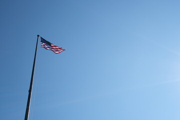 American flag waving with clear sky in background