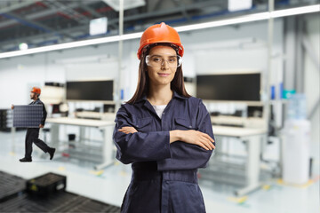 Female worker in a uniform posing in a solar panel factory