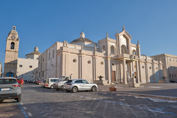 Fototapeta premium The Cathedral of Manfredonia, San Lorenzo Maiorano, with bell tower behind, blue sky