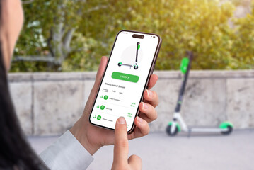 Renting an electric scooter with an app, with mobile phone. Scooter that is unlocked by the app in background © Stanisic Vladimir