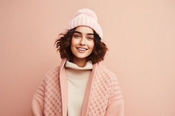Cheerful young woman in winter outfit looking at camera and smiling.