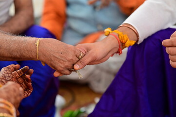 Groom hand with turmeric thread hold hand on bride's father. indian wedding ceremony. Hindu wedding...