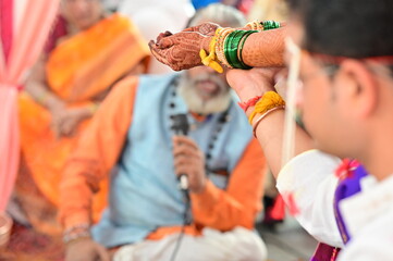 Hands with turmeric thread in indian wedding ceremony. Hindu wedding rituals. Hands of bride and...