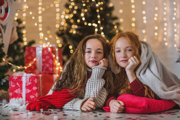 Two teenagers girls in christmas decorations. New year lights garlands. Christmas card with two pretty girls