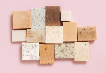 Beige and brown handmade soap bars on light pink top view. Natural herbal product for SPA