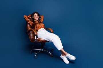 Full size photo of attractive young woman have rest ergonomic dressed stylish brown silk formalwear isolated on dark blue color background