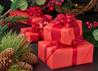 Gift boxes wrapped in red paper against Christmas decor background