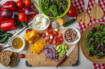 Sliced fresh vegetables for salad lie on a wooden board.