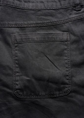 Back pocket of black jeans, close up