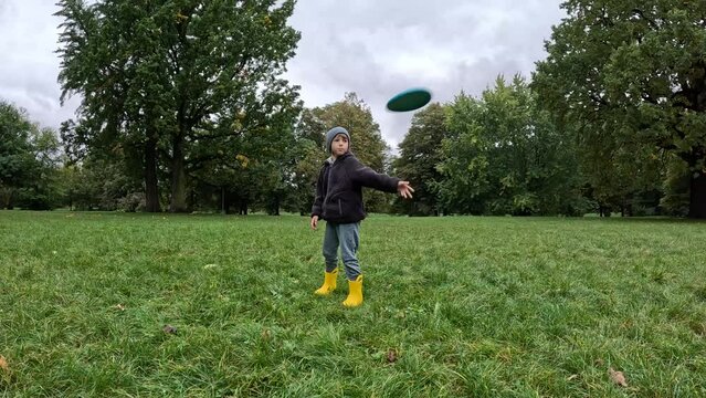 Frisbee Fun Boy Launches a Turquoise Frisbee in the Park on a Stroll. High quality 4k footage.