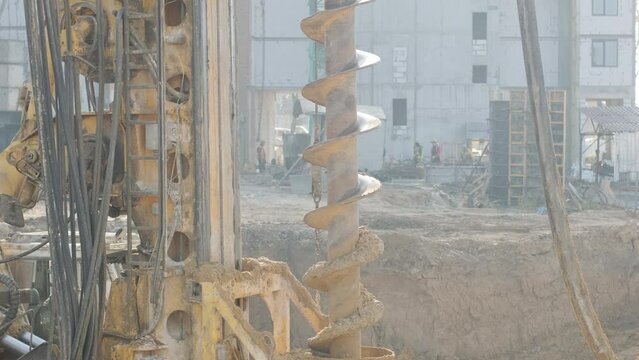 Equipment for installing piles in ground, heavy machines for driving pillars work in laying the foundation building. Construction aerial view height. Construction site drilling pile foundation.