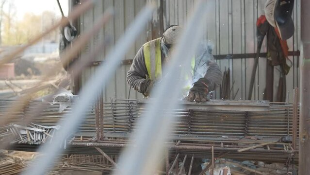 Construction worker welding metal rebar for the pouring of monolithic structure