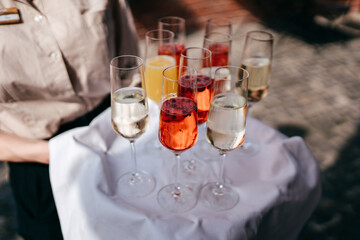 Ein Kellner trägt ein Tablett mit Cocktails und Wein