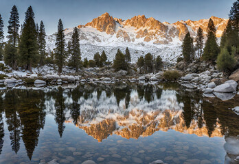 Crystal clear lake reflecting snow capped Sierra Nevada mountains.