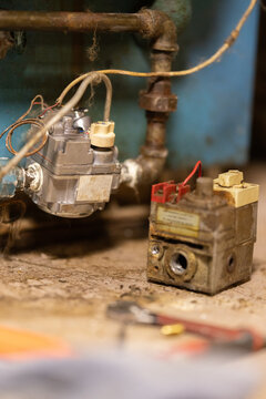 An old house boiler's gas valve has been replaced with a new model. 