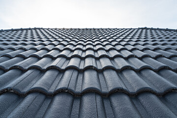 Close up of brown clay roof tiles. Red old dirty roof. Old roof tiles. Construction equipment build a house.