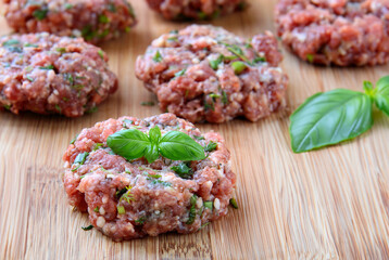 fresh raw burger cutlets on wooden board