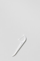 Plastic white dental toothpick with dental floss on white background