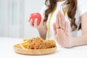 Beauty slim female body confuse French fries and fried chicken. Woman in restaurant achieves weight loss goal for healthy life, crazy about thinness, thin waist, nutritionist. Diet, body shape.