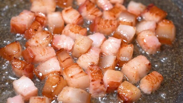 roasting of salted pork fatback on a red-hot pan, close-up	