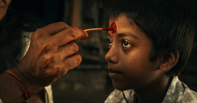 Authentic Footage of Hindu Priest Putting a Tilaka on Male Kid in a Temple. Senior Guru Giving Blessings with a Mark on the Forehead to a Child, Faithful Worshipers in Religious Ceremony
