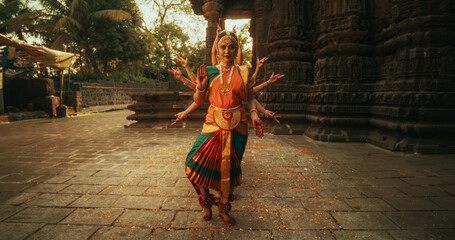 Portrait of Five Women Performing Folk Dance Choreography near Ancient Temple. Indian Women in...