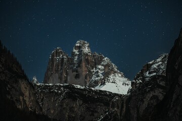 Tre Cime de Lavaredo at night under a starry blue sky