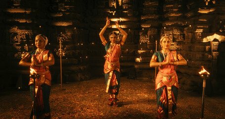 Enchanting Dynamic Shot Showcasing a Lively Ensemble of Indian Women Joyfully Dancing Traditional Folk Inside an Empty Historic Temple. Vibrant and Mesmerizing South Asian Cultural Festivity