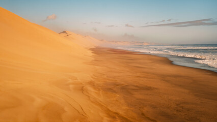 The world?s highest dunes of the Namib Desert descent into the cold Atlantic Ocean at Sandwich Harbor, located south of Walvis Bay in the Namib-Naukluft National Park, Namibia.