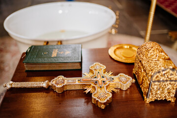 A large Christian cross, a prayer book, and a box on a table in the church