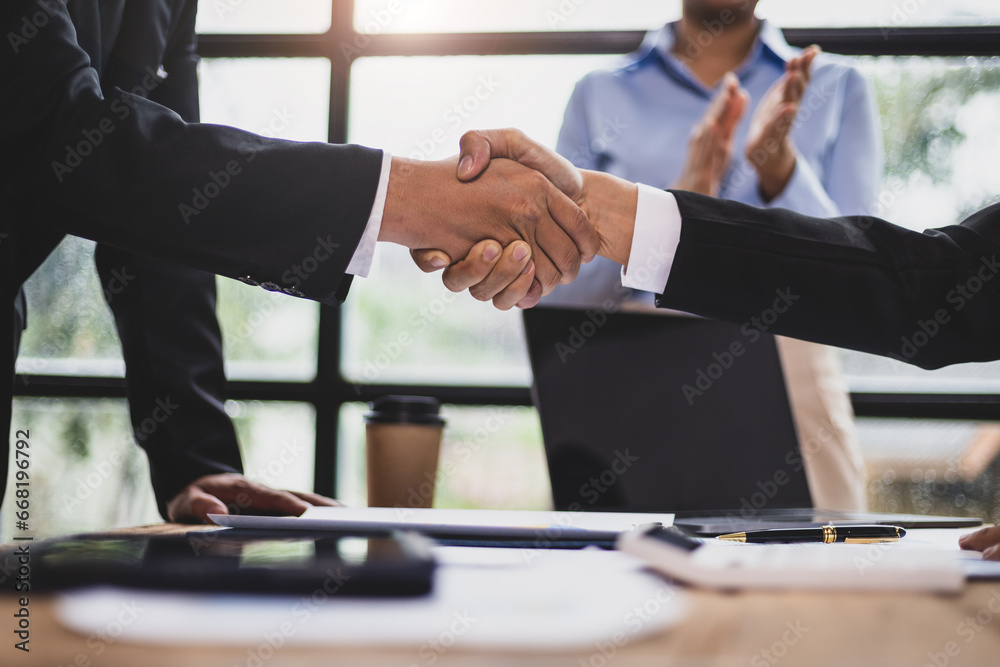 Wall mural businessmen shaking hands at a meeting of business partners.