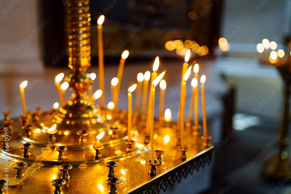 Sticker There are many burning candles on a large candlestick in the church.