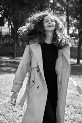 Black and white portrait. Stylish young woman. Close-up portrait of a beautiful girl with brown hair looking at the camera outdoors in the park