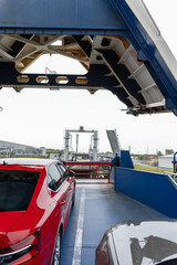 Front open door of passenger freight cargo ferry boat vessel ship with loaded cars and vehicles. Sea transportation ferryboat transport carrier unloading disembark. Northern Europe sea line