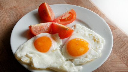 Breakfast. Fried egg and fresh tomato