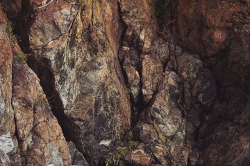 Texture cracked rock formation rock in the wild. Rocky cliff. Abstract Stone texture. Steep cliff of high mountain. Nature background, geological structure. Marble rocks in the wild. Detail Of Granite