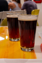 Pint glasses of cold fresh british IPA ale and lager beer served in old vintage English pub