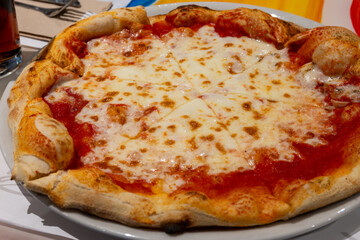 Eating of fresh baked pizza dish in italian pizzeria restaurant