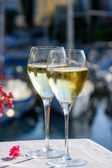 Glasses of cold white Cote de Provence wine in yacht harbour of Port Grimaud, summer vacation on French Riviera in Provence, France