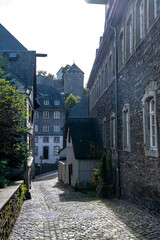 View of houses and streets of old colourful German town Monschau in bend of the river and hidden between the hills, Eifel national park, Germany
